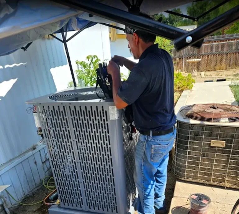 Technician wiring and commissioning a new air conditioning unit in Hemet CA